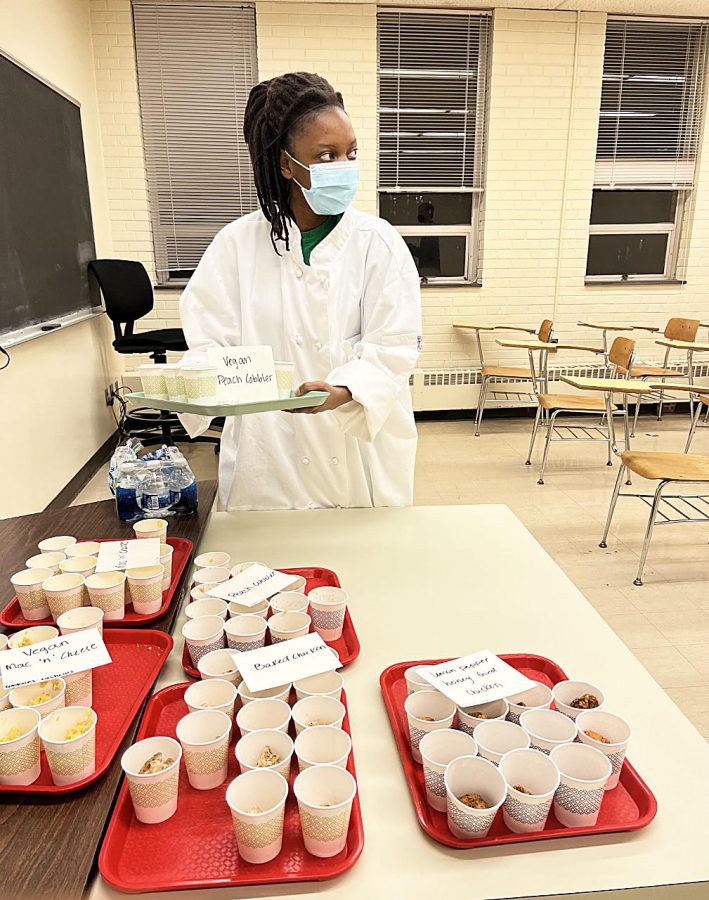 Quera Owens, a nutrition and diabetics graudate student, sets up the soul food presentation in Klehm Hall Thursday evening. The event talks about health diseases related to soul food and gives advice and tips on healthier alternatives along with taste comparisons between various foods made by students. 