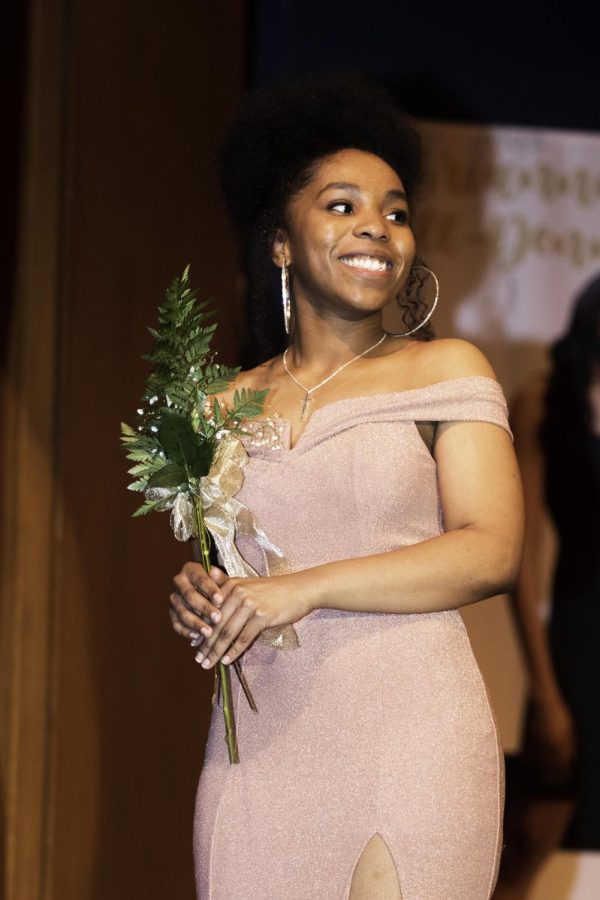 Faith Johnson, a junior business management major, smiles at her family who calls out for her, right before she answers her impromptu question at the 50th Anniversary Scholarship pageant of Miss Black EIU on Saturday night.