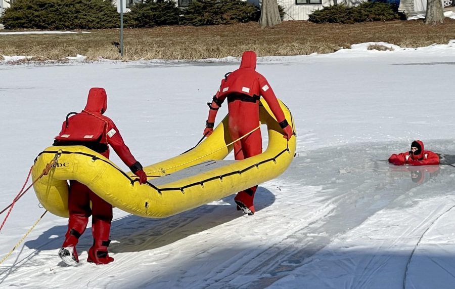 Will Giroux and Allan Colvis, members of the Charleston Fire Department, walk onto the frozen pond behind 9th Street Hall to practice water rescues Tuesday morning.