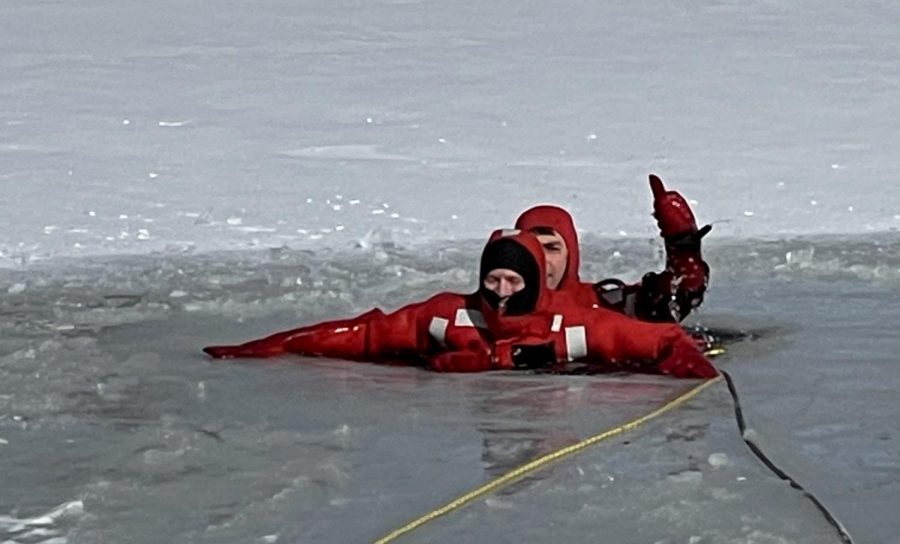 Jeff Adkins and Allan Colvis, members of the Charleston Fire Department, prepare to be drug out of a hole in the frozen pond behind 9th Street Hall Tuesday morning to practice dive rescues. Adkins acted as the rescuee and Colvis acted as the rescuer. 