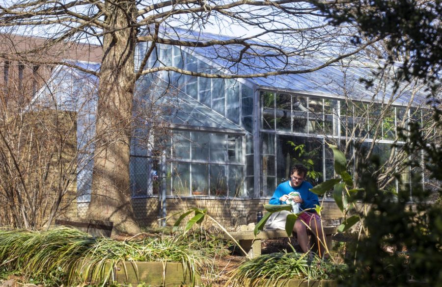 Jonathan Coffin, a freshman nursing major, crochets in the garden next to the Campus Greenhouse on Tuesday. Coffin decided after his last class to enjoy the nice weather and go make a blanket out of yarn.
