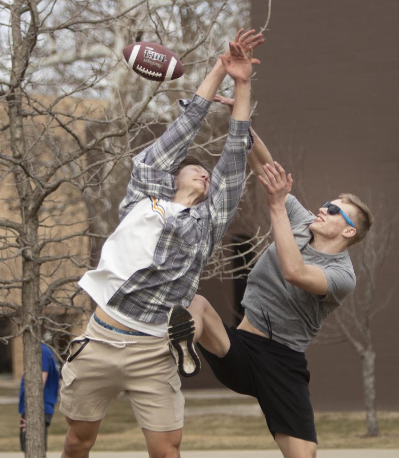 Elijah Skutt, a freshman construction management major, and James Boyd, a freshman emergency management major, both clash into each other while trying to catch a football in the Libray Quad Wednesday afternoon. Skutt and Boyd enjoy the pop-up Mental Health Play sponsored by Student Affairs where multiple activities were available to do like soccer, football, go-karts, petting comfort dogs, playing spike ball, and eating ice cream.