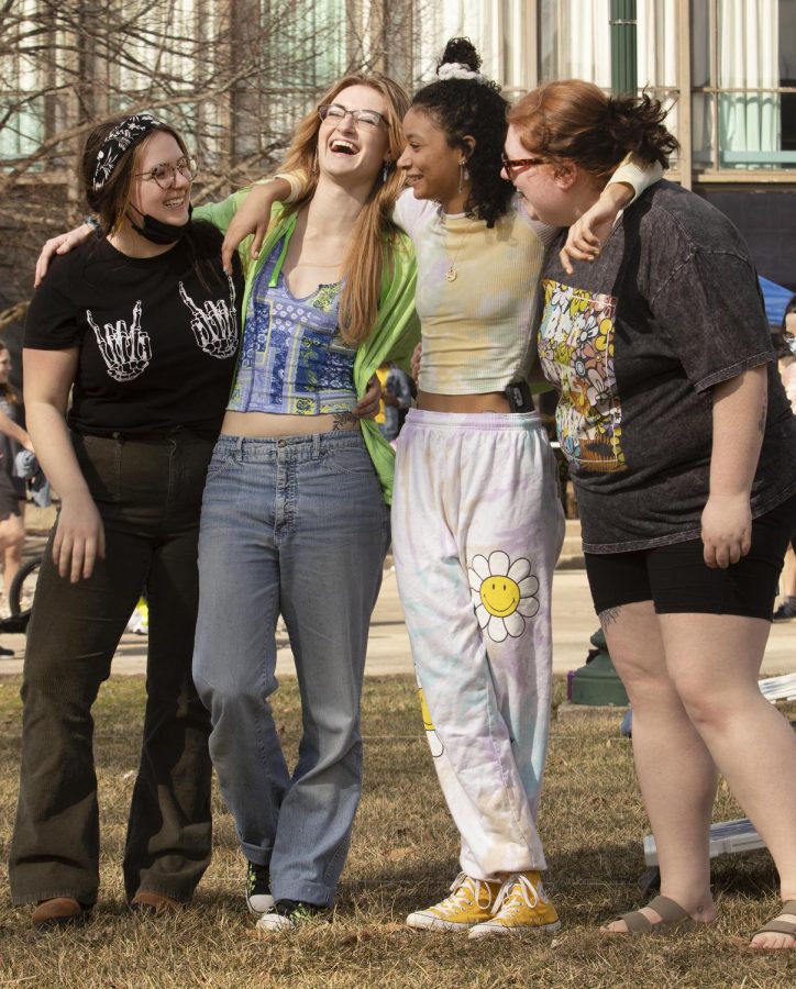 A group of friends hang out in the Library Quad together for the mental health pop-up event and do the different activities available such as playing spike ball and eating ice cream.