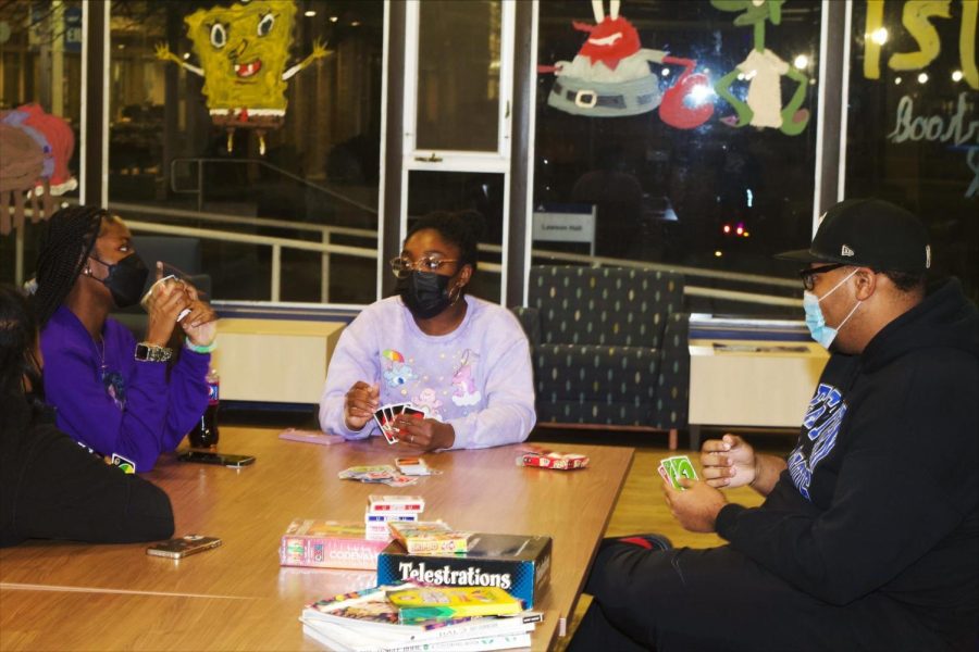 From left, Olutoyike Omokaiye, a freshman biology major, Azaria Bell, a sophomore communications disorders and sciences major, and Justus Lopresto-Jackson, a sophomore computer information technology major, play Uno during the Freshman Connection game night in the Lawson Hall lobby on Friday.