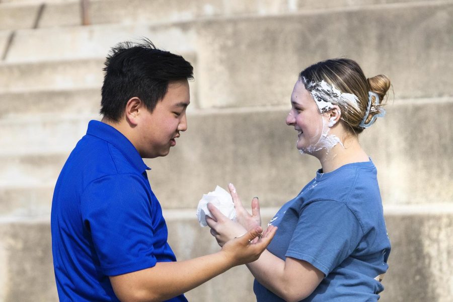 Michael Barth, a junior physical education major, helps Kylie McFarland, a sophomore elementary education major, clean whipped cream off of her face after getting pied for the Pie a Kappa Delta event.