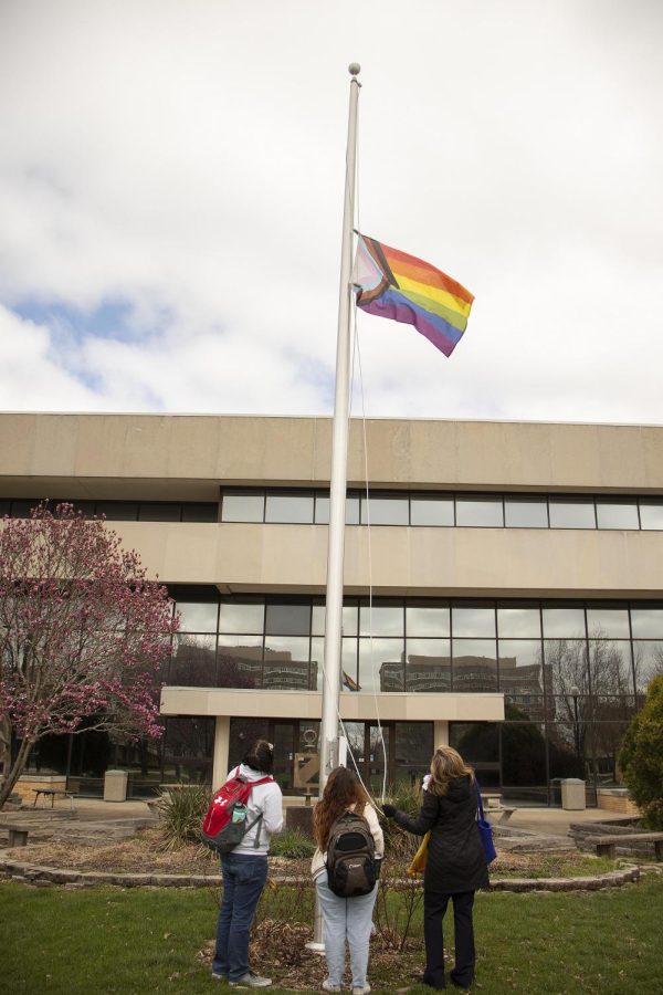 From left, Payton Ade, a sophomore interpersonal communications major, Jaclyn Thomas, a senior interpersonal communications major, and Anne Flaherty, the Vice President for Student Affairs, help each other to raise the pride flag in the South Quad. 