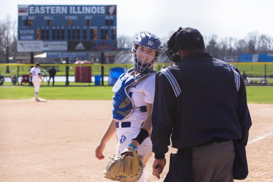 A softball player smiles and talks with the umpire at Sunday’s game vs. the Murray State Racers on Williams Field.