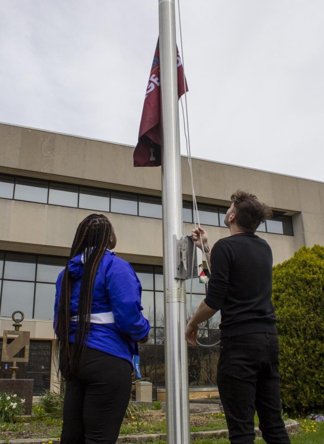 From left, Shariah Campbell, a graduate student studying human service program administration, andAdam Reedy, a primary counselor at TRIO, raise the Asian American and Pacific Islander Heritage Month flag Monday at noon. The flag is raised in April instead of May because students wont be on campus in May. 