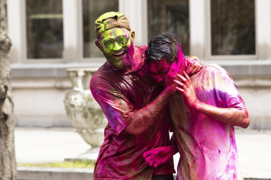 Shashank Vangari, a computer technology graduate student, covers his friend, Pranay Ravuri, a computer technology student, in pink powder during the Holi festival celebration in the North Quad Thursday afternoon.