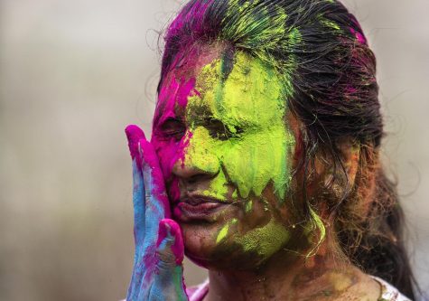 Sai Supraja Yendeti, a graduate student studying technology, smiles as someone smears colored powder on her face during Easterns Holi event Thursday in the North Quad.