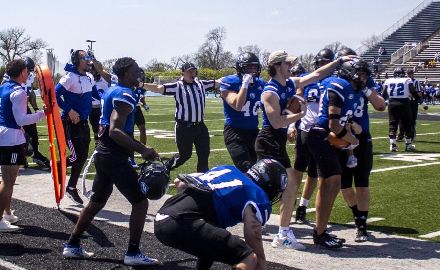The defensive line celebrates after Collin Tyson, a freshman sport management major, intercepted the ball on a throw during the Alumni Social Spring Game Saturday afternoon at OBrien Field.