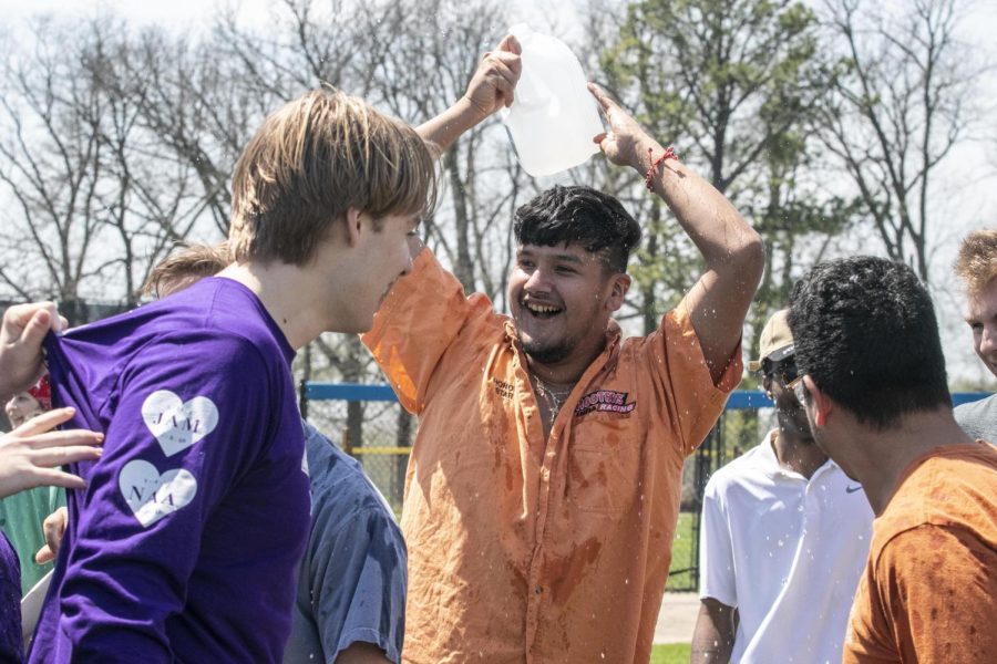 Jesus Alejandro, a senior finance major, dumps water on the Sigma Pi Epsilon team to celebrate their first place in the tugs finals Saturday afternoon.