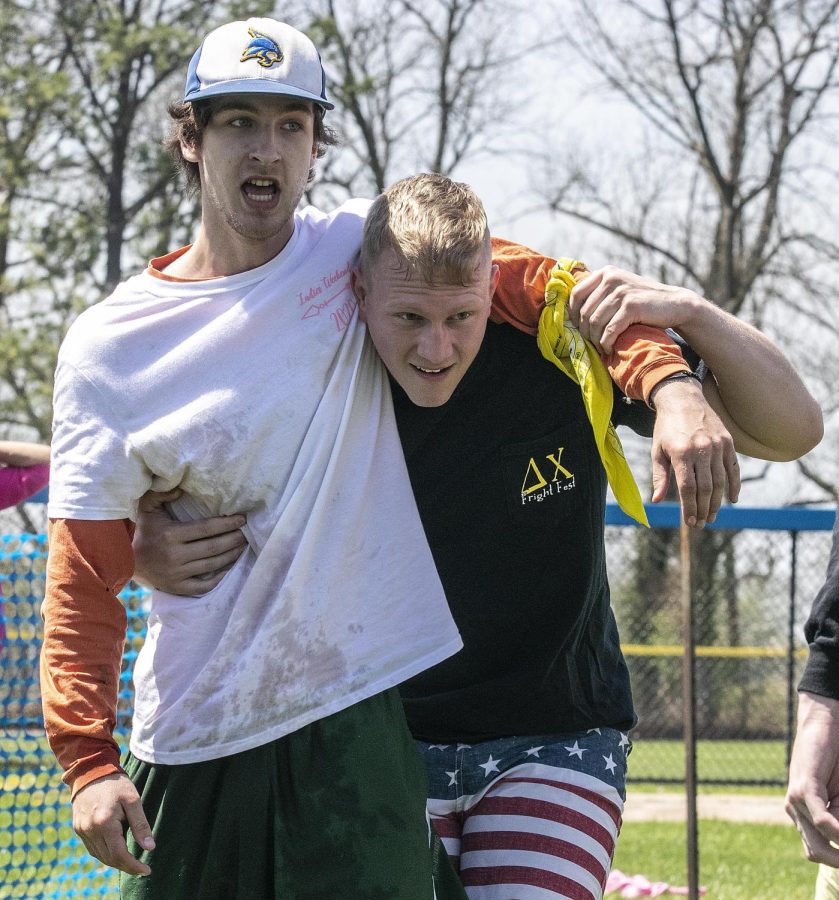Delta Chis tugs coach Branden Lawrence, a sophomore exercise science major, helps Elijah Erck, a sophomore physical education major, up after they won third place at the tugs finals Saturday afternoon.