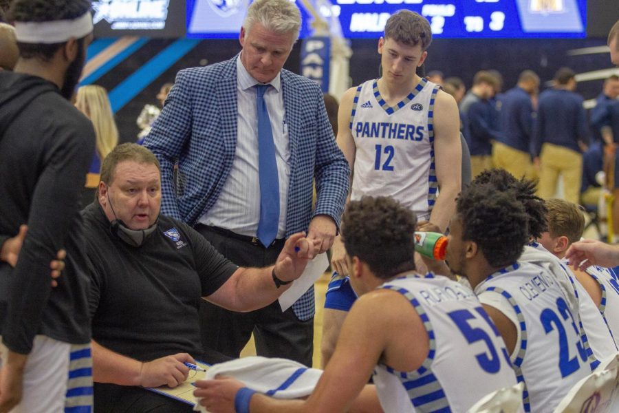 The Eastern men’s basketball head coach Marty Simmons (seated left) instructs players on what to do during a timeout during the Panthers’ game against Murray State on Jan. 17 at Lantz Arena. The Panthers lost 72-46 to the Racers.