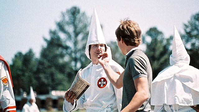 A young man flipping off a member of the Ku Klux Klan in 1986 in Auburn, Alabama.