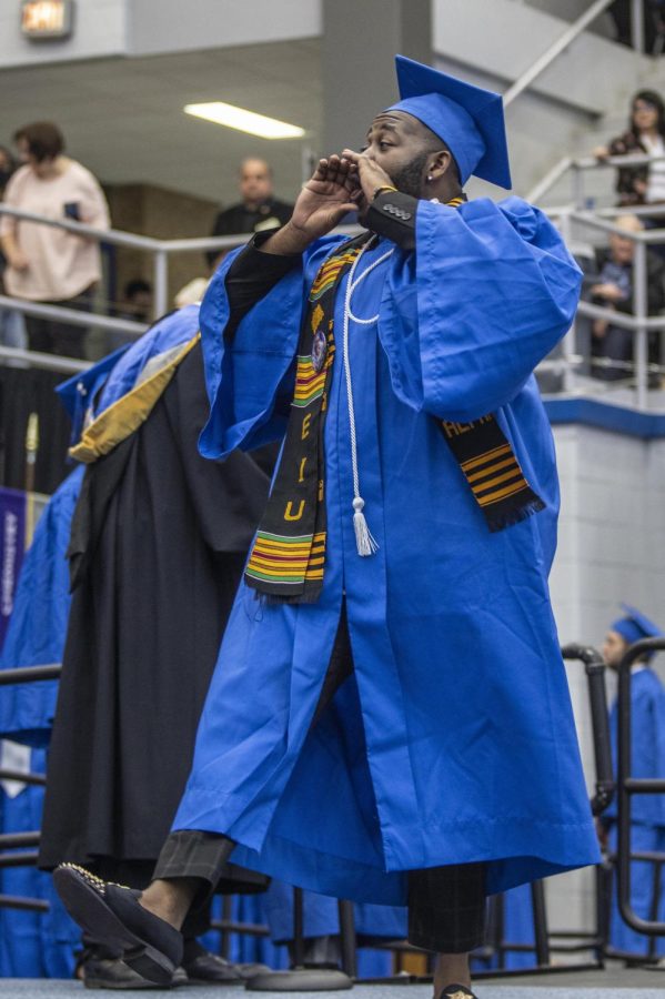 Percy Williams, President of Alpha Phi Alpha Fraternity Incorporated, calls out to brothers of the fraternity while walking towards Eastern Illinois University President David Glassman to receive his degree in sociology during the spring commencement ceremony Saturday afternoon in Lantz Arena.