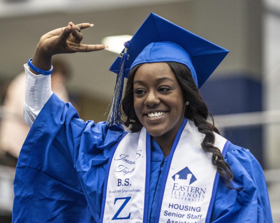 Alumn Imani Tapley, a member of Zeta Phi Beta Sorority Incorporated, calls out to her sorority sisters while walking towards Eastern Illinois University President David Glassman to receive her degree in broadcast journalism during the commencement ceremony Saturday afternoon in Lantz Arena.