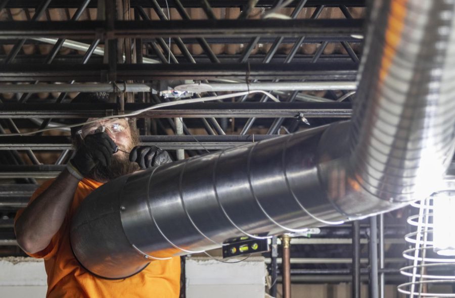 Brian Carter, a worker for King-Lar Company, fastens a vent in one of the science labs in the Life Science Building.