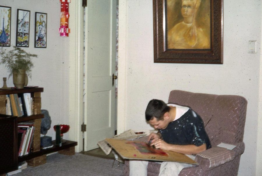 Young Jim Johnson sits in an armchair working on a sculpture.