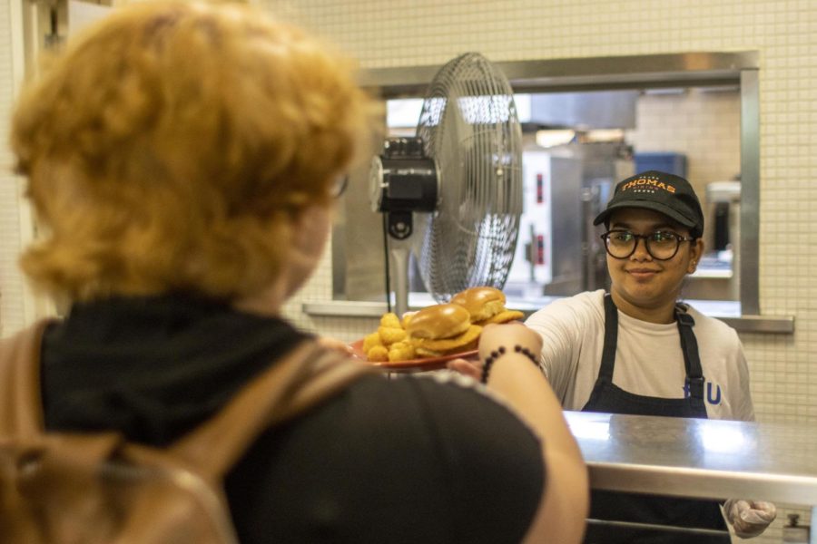 Mahveen Arshi, a graduate student studying computer technology, serves chicken sandwiches and tater tots at Thomas Dining Aug. 29. Starting the 22-23 school year, Taylor Dining will only be open for breakfast and lunch. Because Taylor had the allergen meal choices, Thomas Dining now offers allergy-friendly meals.