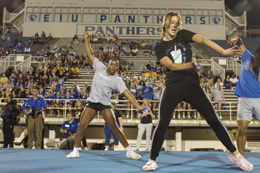 Abbey Vollmer, a junior communications disorders and sciences major, and volleyball player TaKenya Stafford, a sophomore journalism major, dance the Cha Cha Slide during First Night at OBrien Field Sunday night.