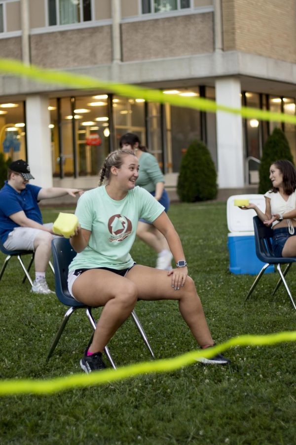 Haleigh Harpole, a senior early childhood education major, gets ready to throw damp sponges at her opponents on the other side of the net in a competitive game of Battleship during the Christian Campus House lawn party in South Quad Tuesday evening.