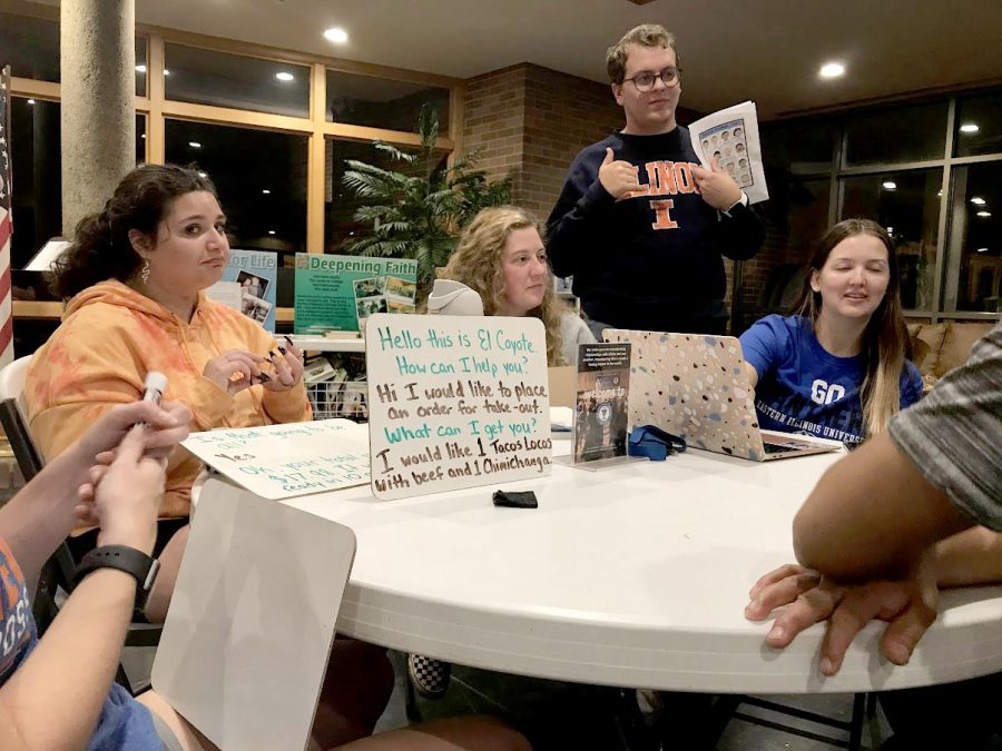 Students help teach English to fellow students who dont speak it, Wednesday night at the Newman Catholic Center.