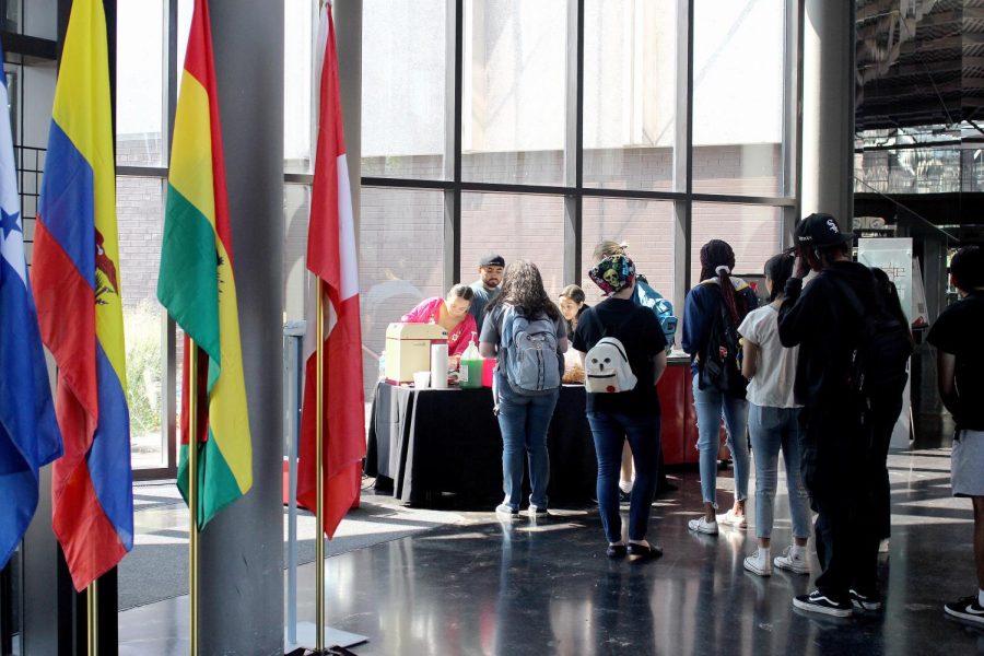 Students stand in line, waiting to purchase raspados and chicharrones to help the Latin American Student Organization fundraise for the year in the Doudna Fine Arts Center Thursday afternoon.