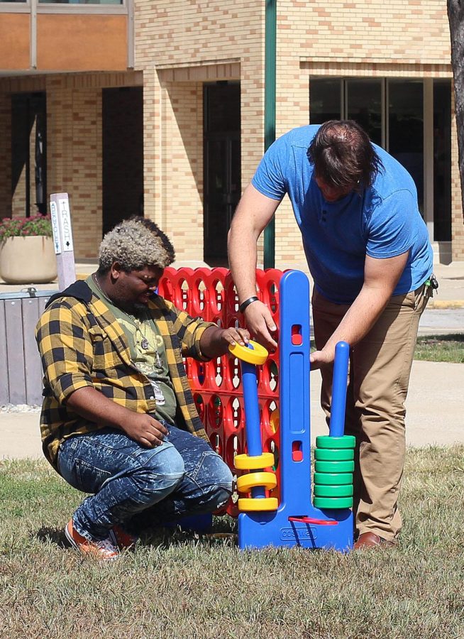Sean Haynes (left), a senior music major, and Matt Chesner (right), a graduate student studying music, play giant Connect Four Library Quad for part of a Mental Health Pop Up Day event Tuesday afternoon.