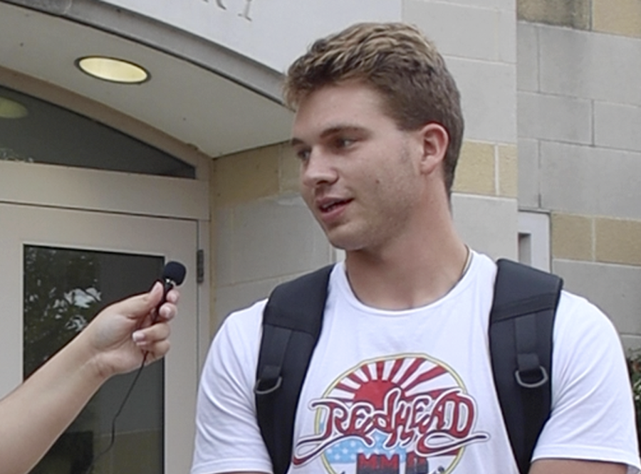 Drew Shrader, a senior marketing major, talks about personal financial status while attending college Saturday afternoon outside Booth Library.