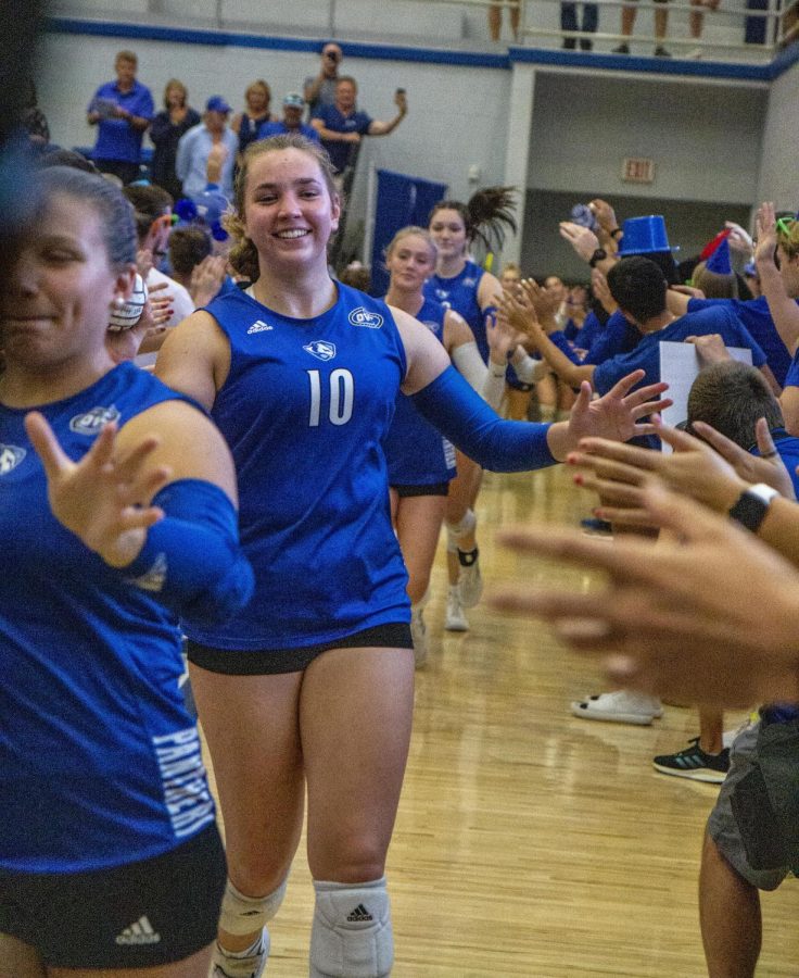 Tori Mohesky, a freshman outside hitter and opposite hitter, runs through a tunnel clapping fans hands before the start of the volleyball game against the Illinois State University Redbirds at Lantz Arena Wednesday evening. The Panthers lost 3-0 to the Redbirds.