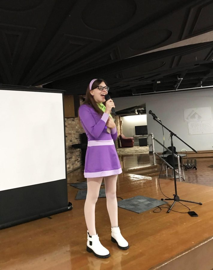 sabella Ladesma, a freshman critical writing major, and dressed as Daphne from Scooby Doo, sings Cooler Than Me by Mike Posner for karaoke at the Calling All the Monsters! event, a costume party and karaoke night in 7th Street Underground of the Martin Luther King Jr. University Union.