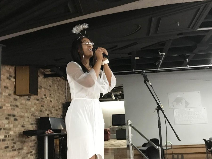 Tatiana Stringer, a sophomore health administration major, dresses up as an angel and sings Halo by Beyonce for karaoke at the Calling All the Monsters! event, a costume party and karaoke night in 7th Street Underground of the Martin Luther King Jr. University Union.