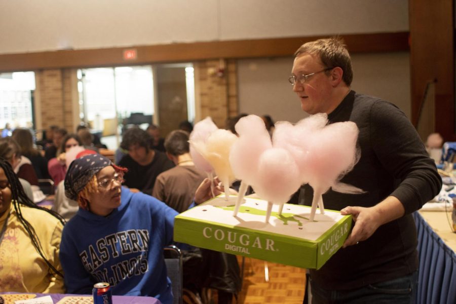 Justin Richards, a strategic communications graduate student, hands out cotton candy to families at the family bingo night in the Grand Ballroom of Martin Luther King Jr. University Union.