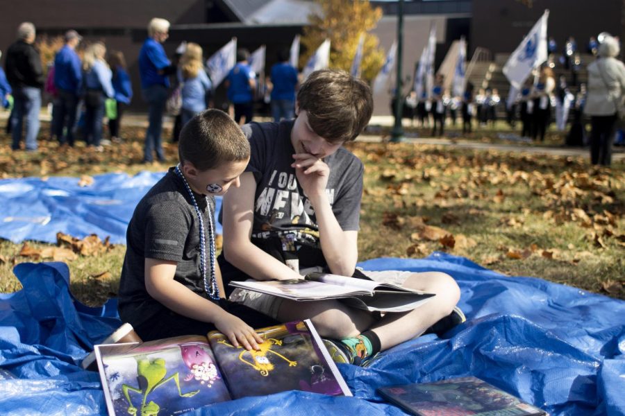 Chris Andrus, a freshman vocal performance and audio recording technology major, reads books to his nephew during the Family Reading Time for Family Fun Fest in front of Booth Library.