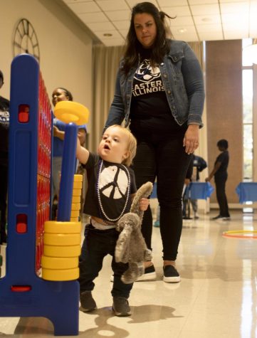 Molly Fasnacht lets her child play around with different games at family fun night in the University Ballroom of Martin Luther King Jr. University Union.