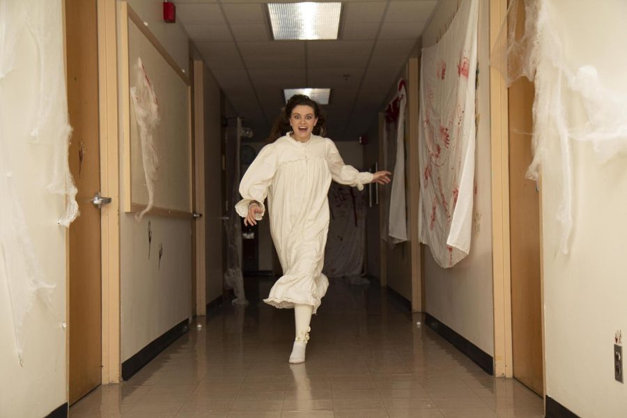 Chronicle Nagel, a junior music education and vocal performance major, chases people down the hallway to scare people at the Pemberton Hall haunted house, an event to donate money for the nonprofit organization Girl Forward on Friday and Saturday night. 