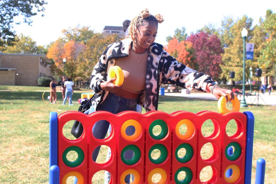 Destiny Reed, a senior fashion merchandising and design major, plays tic-tac-toe with her friends in the Library Quad at the Homecoming Kickoff on Monday afternoon.