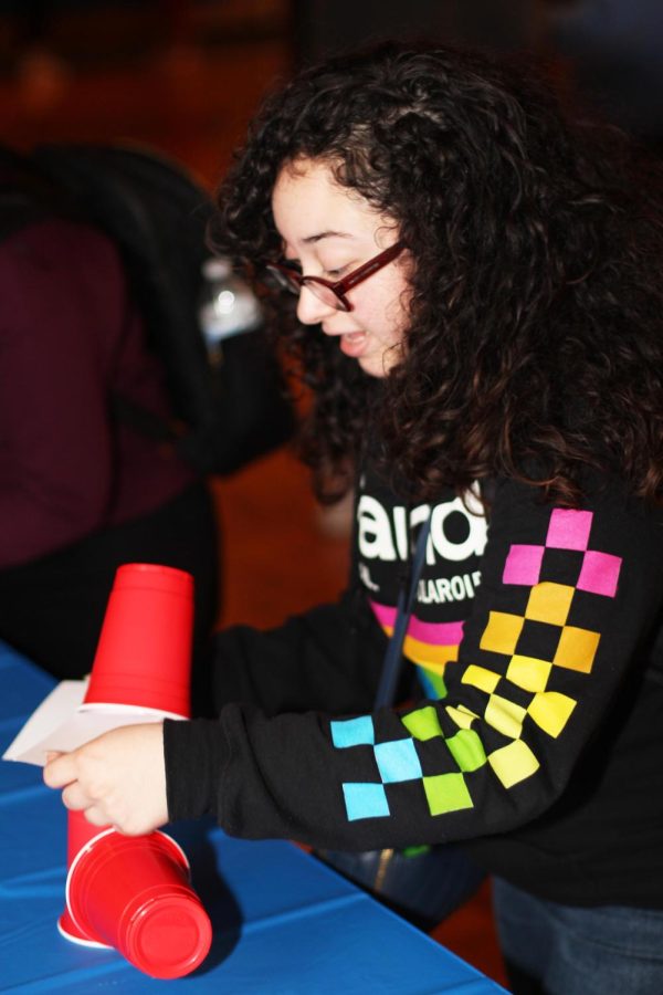 Jasmine Rivera, a graduate student with a masters in art, tries to pull notecards from in-between cups on Tuesday night in the Grand Ballroom of Martin Luther King Jr. University Union.