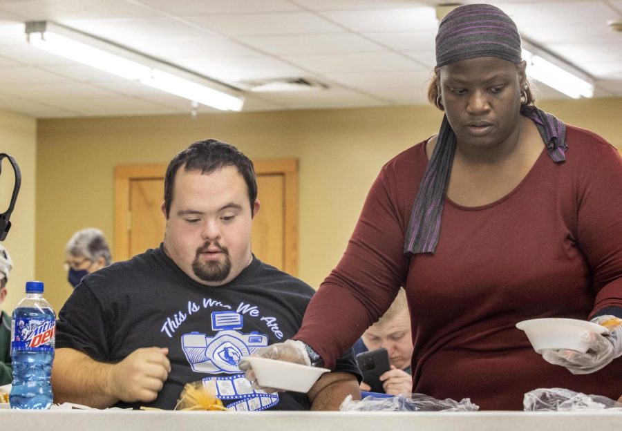 Eric Plummer is handed a bowl of chili during the CCAR Thanksgiving luncheon Tuesday afternoon at CCARs manufactoring plant. Plummer grew up watching Eastern sports games. He works two jobs, the first as a CCAR manufacturing worker and the second as a janitor. 