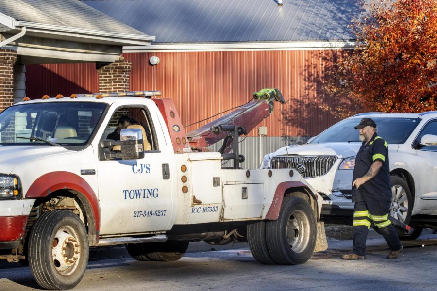 A worker from CJs Towing hooks up one of the damaged vehicles to the towing jack Thursday afternoon at the intersection of Division Street and Madison Avenue. The accident involved two vehicles with both people involved uninjured according to Charleston police. 