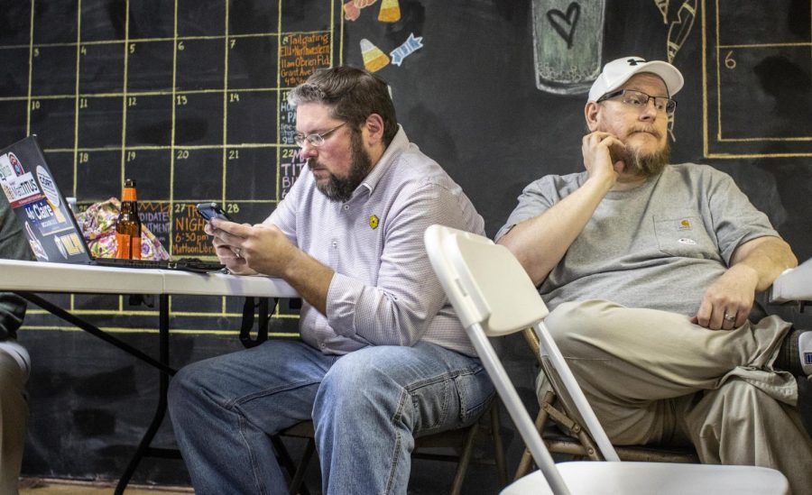 From left, Matt Titus, a democratic candidate for district 11 of the Coles County Board, browses on his phone after seeing the election results where he lost while his husband Wesley Allen, an Eastern associate professor in clinical psychology, looks off in the distance at the Coles County Democrats watch party at the organizations headquarters Tuesday night in Charleston.