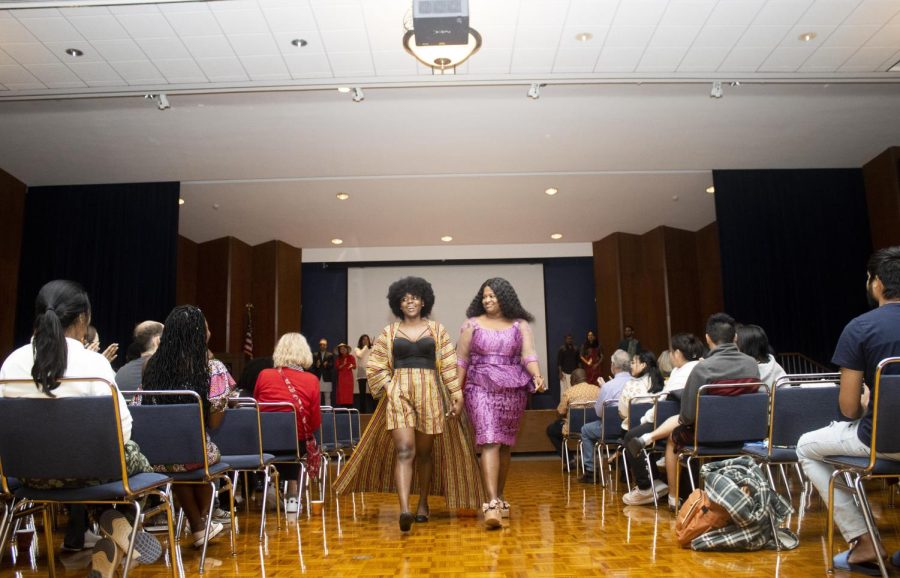 Oyewole, a computer technology graduate student from Nigeria, and Onyekachi Okoh, a freshman digital media technology major from Nigeria, hold hands and walk together in the fashion show during the Global Culture Night in the Grand Ballroom of Martin Luther King Jr. University Union.