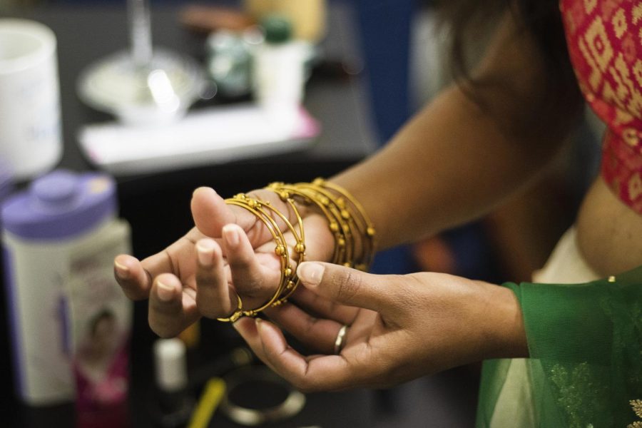 Sajani Reddy Singapuram, a computer technology graduate student, puts on bracelets as apart of her outfit to get ready to perform in the Global Culture Night event.