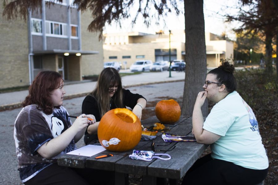 Emily Hood, a freshman accounting major, Frannie Harris, a freshman psychology major, and Brooke Renaud, a freshman english major, spend the afternoon outside Thomas Hall designing and carving pumpkins together on Wednesday.
