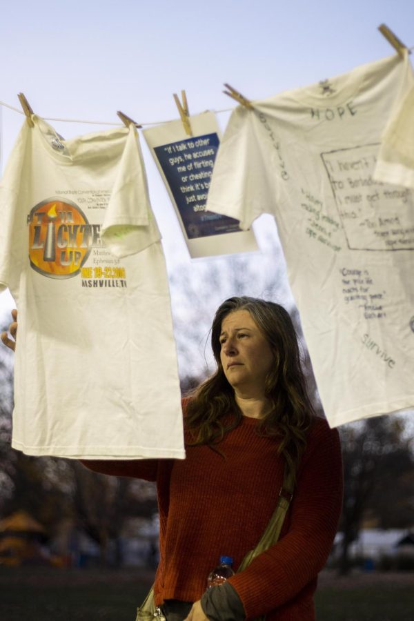 At HOPEs candlelight vigil, a woman views The Clothesline Project that have messages left by domestic violence survivors at HOPEs candlelight vigil to honor people who have passed away from domestic violence.