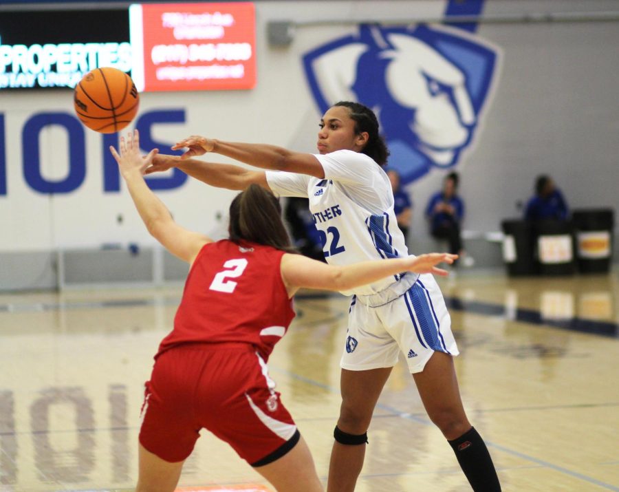 Senior guard Lariah Washington (22), passes the ball to a teammate, avoiding the hands of Brave freshman guard Lucia Llaveria (2), during the womens basketball game at Lantz Arena Tuesday night. Washington led the Panthers with 19 points and 4 assists. The Panthers lost 72-61 to the Bradley Braves.
