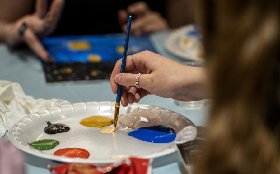 Students were able to paint with brushes or finger-paint along with the instructor during the Winter Welcome Days Paint and Sip event in the University Ballroom Tuesday night.