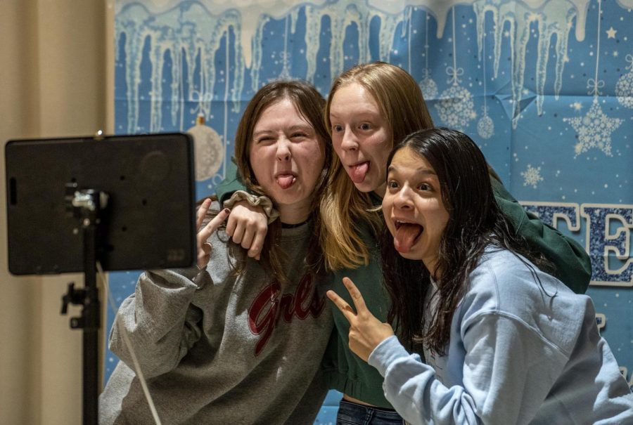 From left Alyssa Marino, a senior English major, Caleigh Parsley, a senior community health major, and Tiana Luna, a senior early childhood education major, pose for a drop-scene photo at the Winter Welcome Days Paint and Sip in the University Ballroom Tuesday night. The group expressed how much they love coming to the free events Eastern hosts.