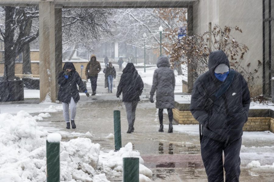 Students eagerly refreshed their inboxes awaiting the desired class is canceled email after seeing a snowstorm Wednesday morning. Devin Melvin (right) a freshman accounting major, trudges through the snow on his way to class wearing a makeshift gator mask using a blue T-shirt in between Klehm and Lumpkin Hall. Classes were not canceled due to last weeks average temperature hanging around the upper 30s. 